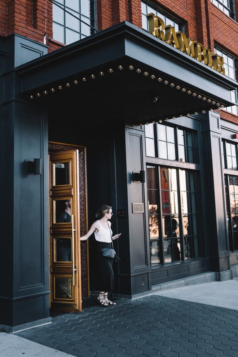 Woman Leaving the Ramble Hotel through the Front Door