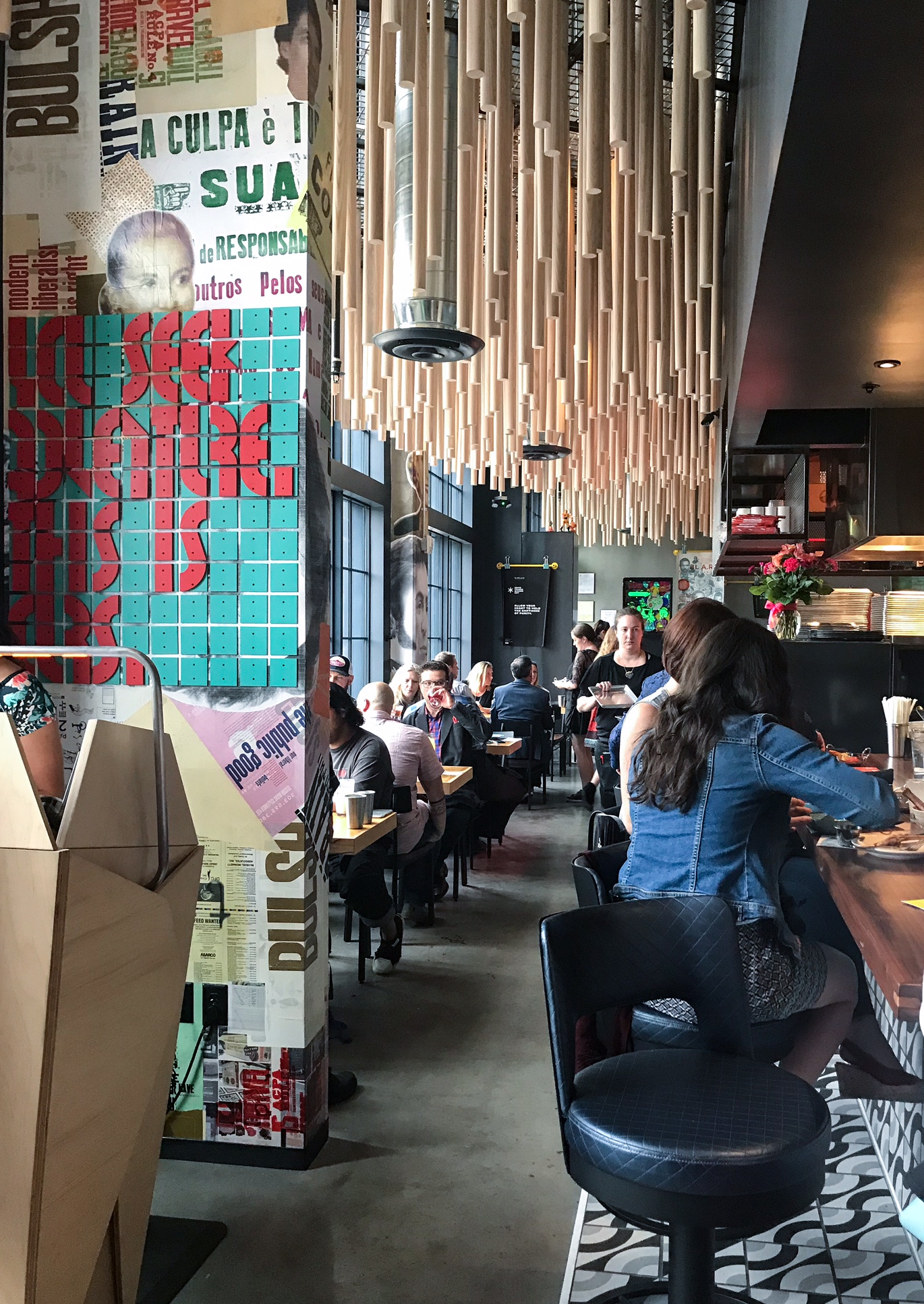 Long shot inside the Super Mega Bien restaurant. Each seat by the window is filled with patrons.